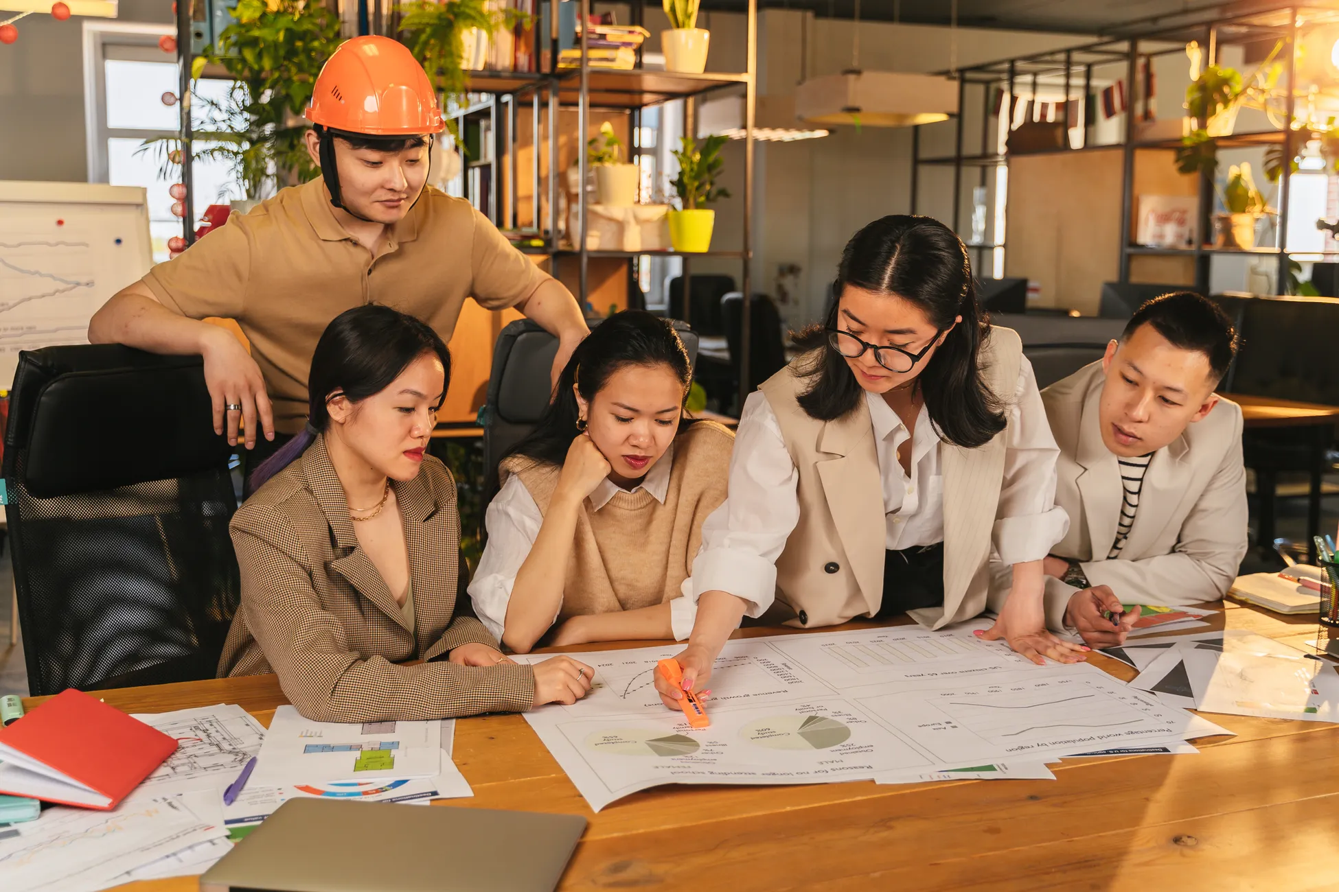 A diverse team of professionals working together on architectural plans in a modern office setting.