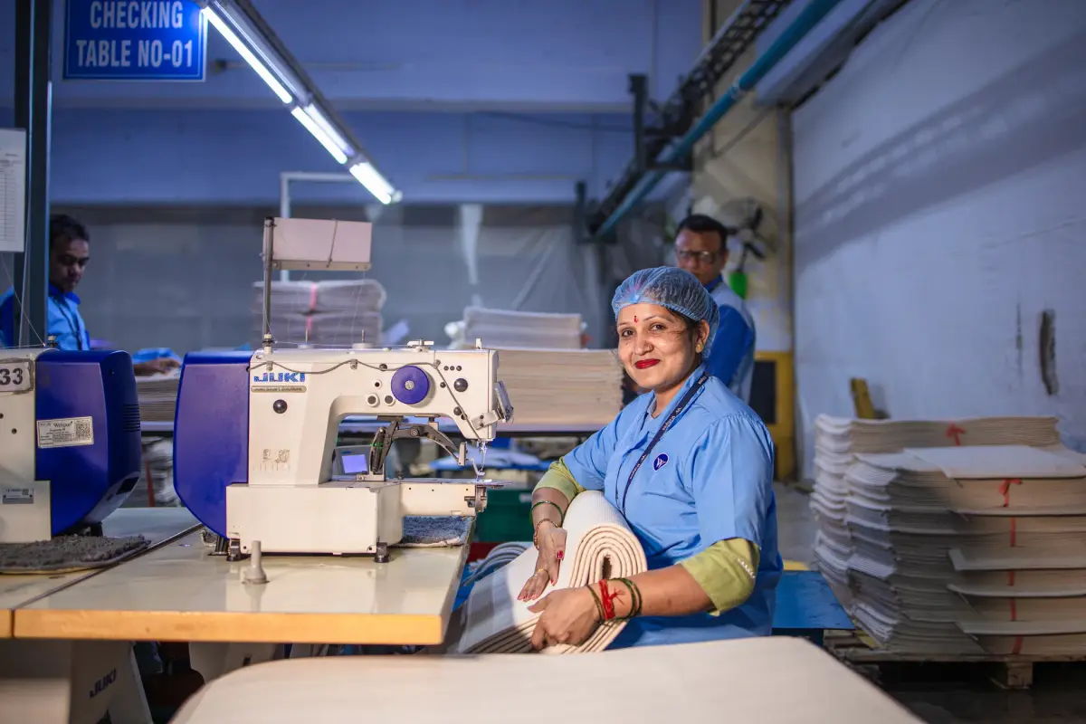 Konfeksiyon atölyesinde kumaş kalitesini kontrol eden bir işçi