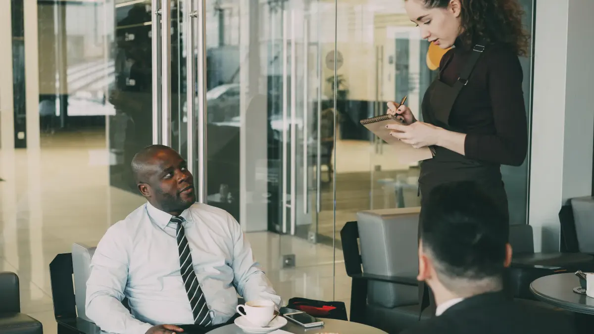 Professionals having a business meeting in a stylish coffee shop environment.
