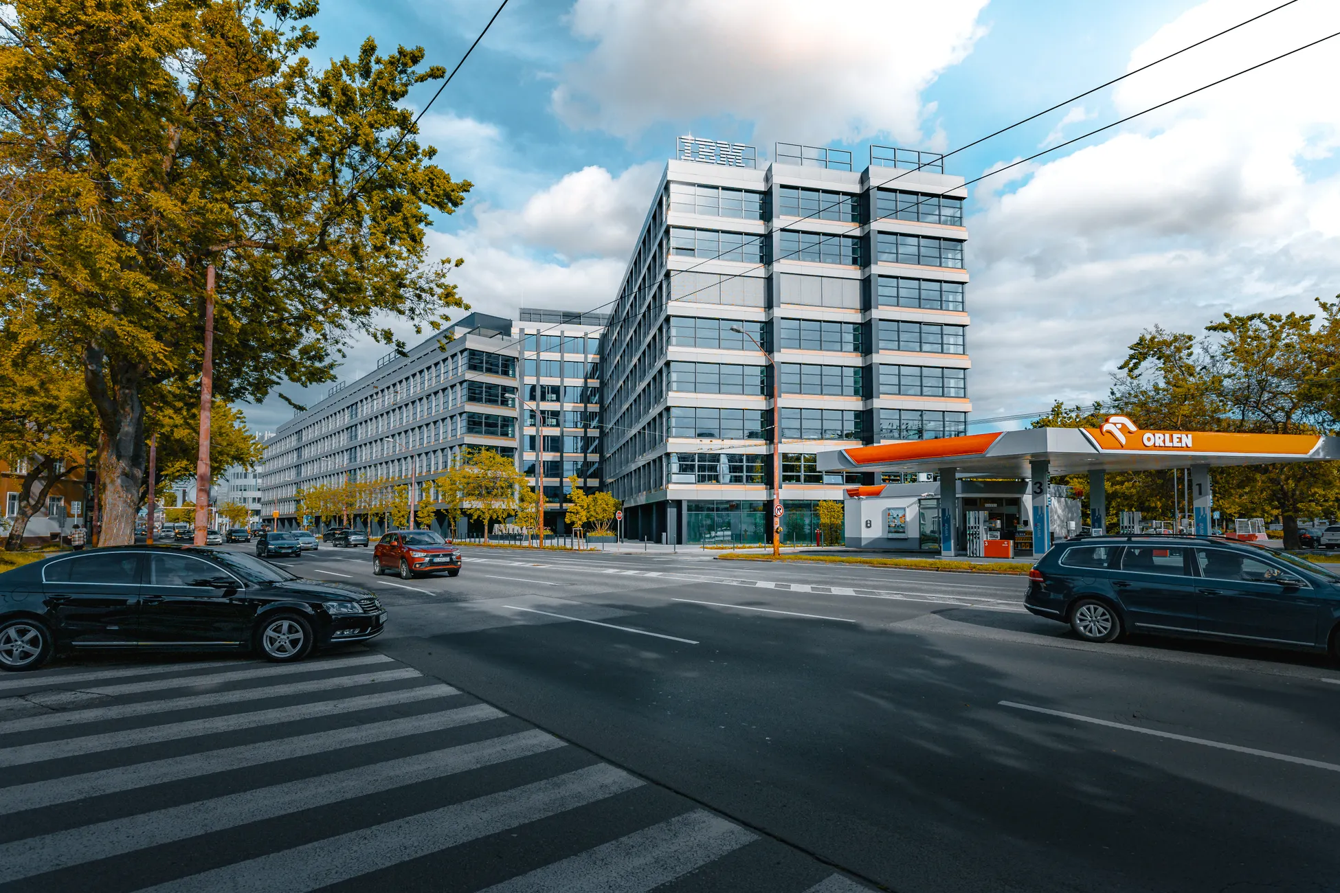 Wide view of a city intersection with modern buildings and an Orlen gas station.