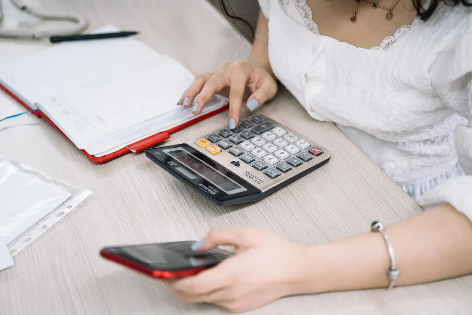 hesap makinesiyle analiz yapan aktüer, veri tablolarını inceleyen finansal kontrolör, modern of of ortamında finans profesyoneli