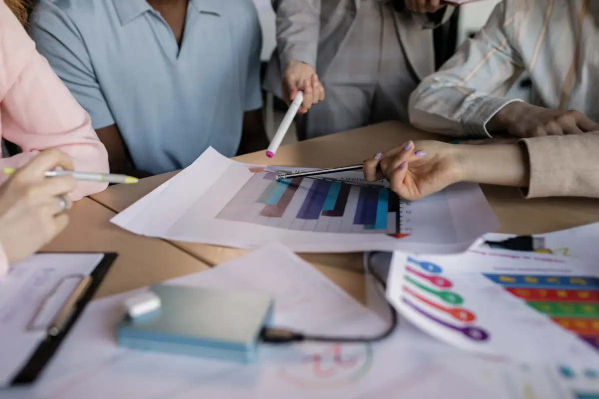 A diverse team engaged in planning and discussing a business strategy around a wooden table indoors.