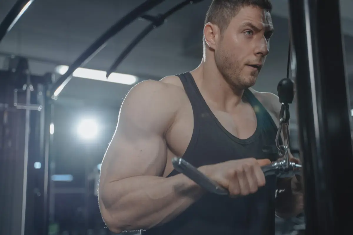 A focused man exercising in a gym, showcasing strength and fitness.