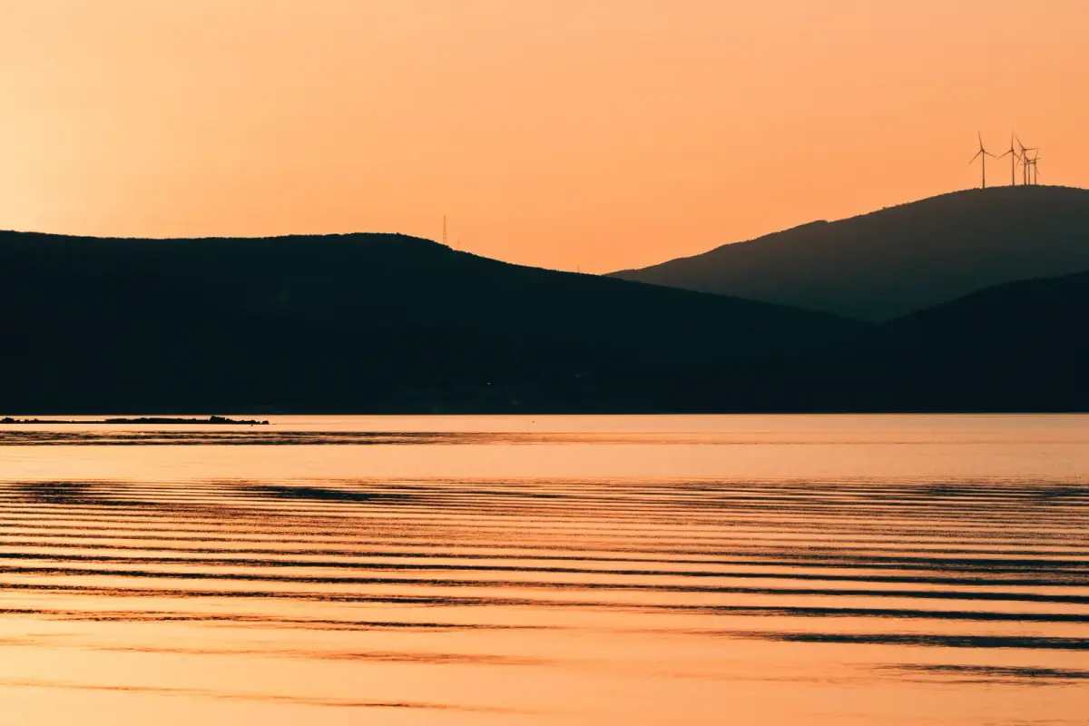 Gün batımında Ege Denizi'ne bakan bir yamaçtaki rüzgar türbini