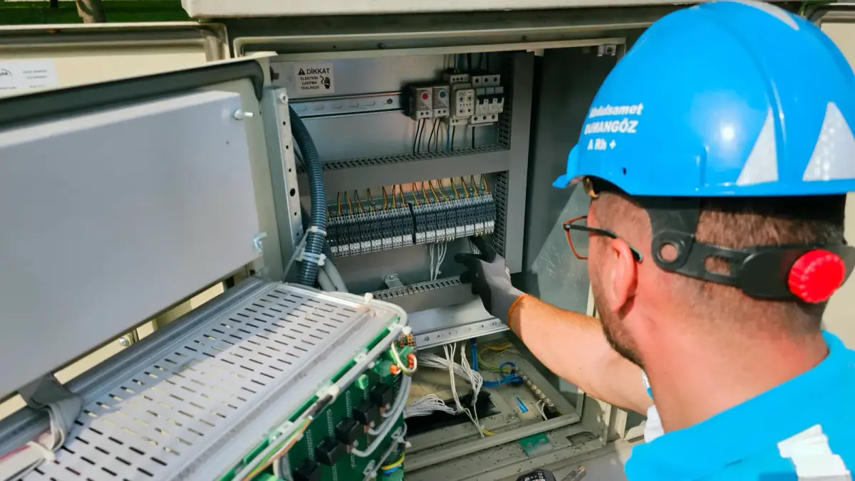Teknik bir teknisyenin elektrik panosu üzerindeki titiz çalışma ve ölçüm süreci.