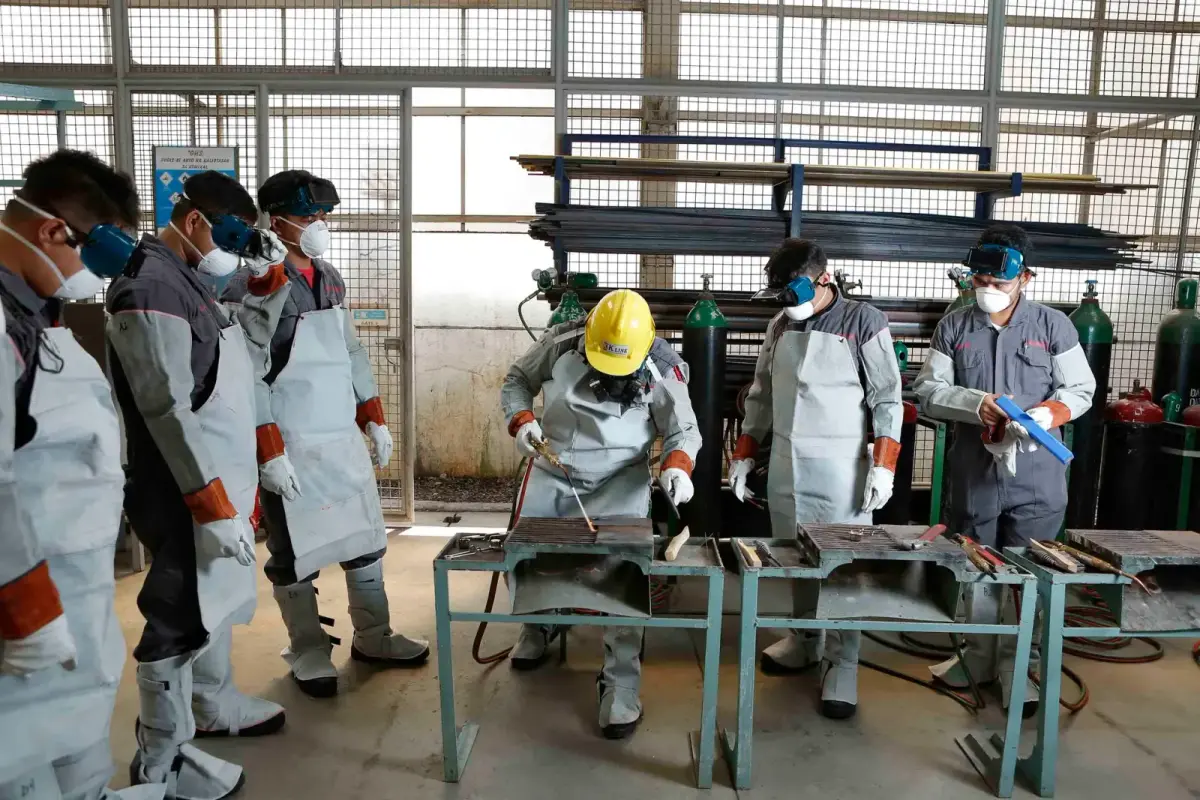 Group of workers in protective gear engaged in factory training in the Philippines.