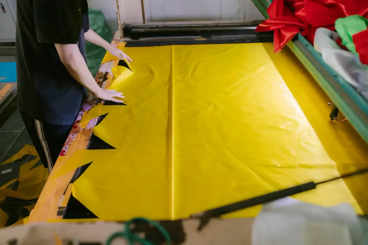 Tekstil fabrikasında kumaş kesim işlemi yapan bir konfeksiyon çalışanı
